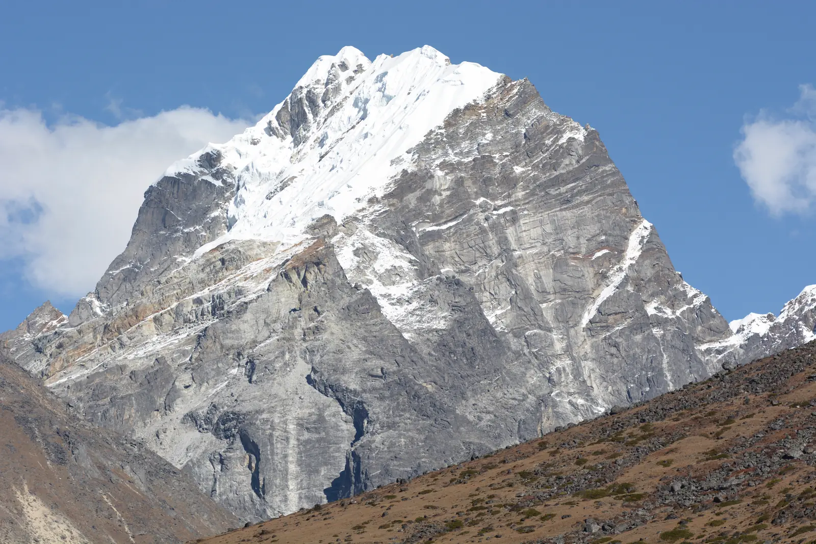 Lobuche East rising in grey rock faces to a snowy summit ridge, seen from the south-east.